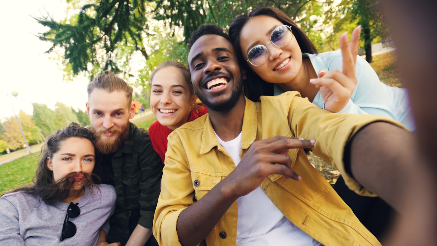 A diverse group of friends laughing together in a park