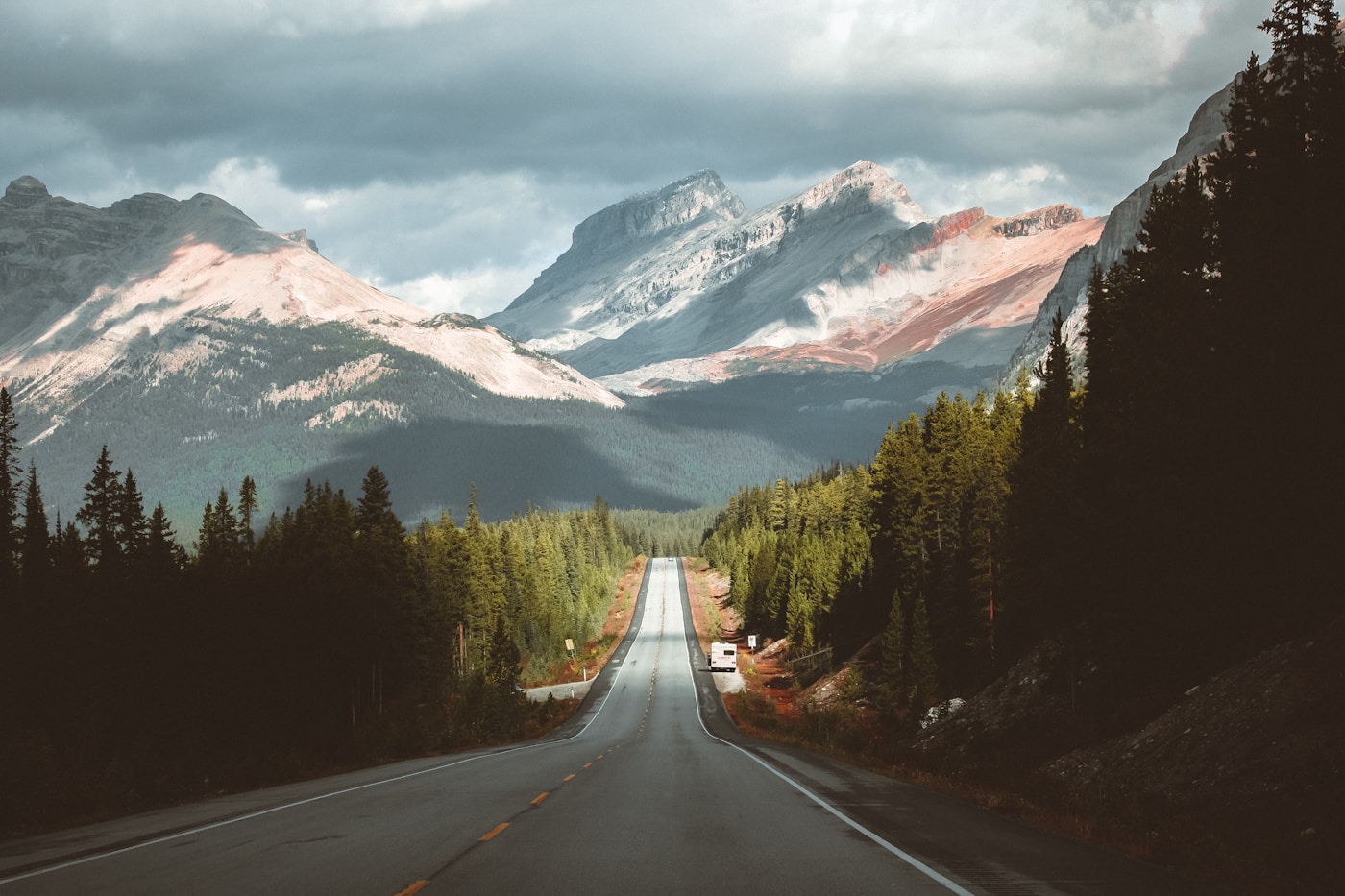 An open road leading into the Canadian Rockies