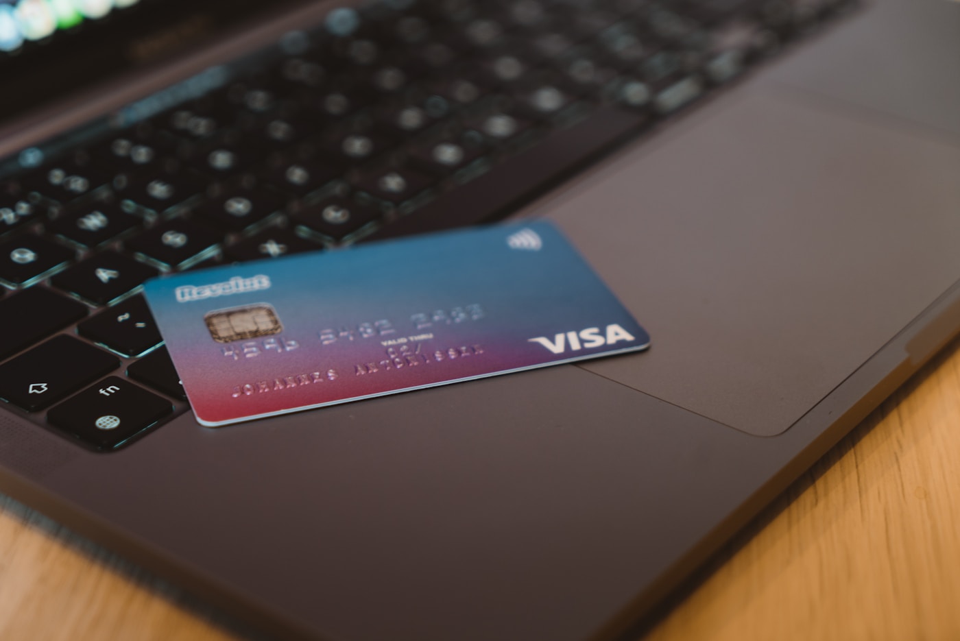 A bank card resting on a laptop, representing online banking